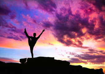 Yoga silhouette on cliff