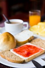 Coffee,bread, and juice in a dish on the dining table.