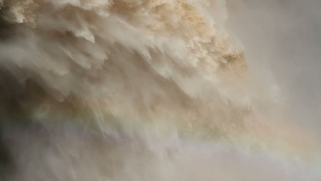 Flowing water with water spray from open sluice gates of a dam