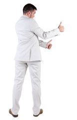 Back view of young business man in white suit going thumb up