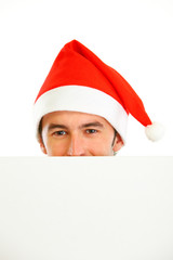 Hiding in front of blank billboard guy in Santa Hat