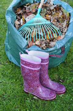 Laubsack und Rechen und Gummistiefel