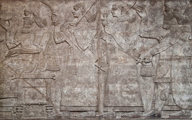 Assyrian clay relief depicting  warriors and cuneiform writing