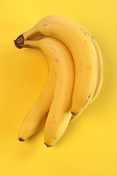 Fresh bananas on a yellow background