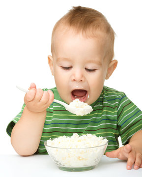 Little Boy Is Eating Cottage Cheese Using Spoon