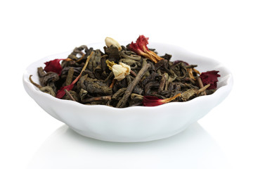 Green dry tea leaves in plate isolated on white