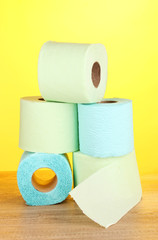 green and blue rolls of toilet paper on wooden table
