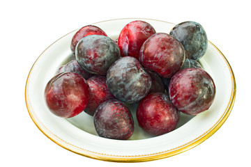 Dish of whole, ripe plums, with natural wax bloom