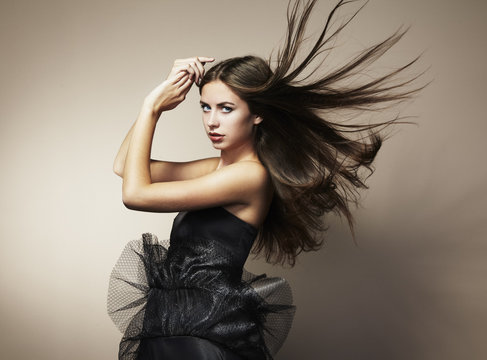 Portrait of young dancing woman with long flowing hair. Fashion