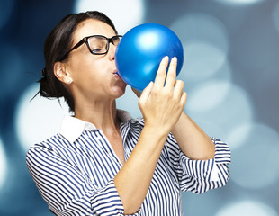 woman blowing balloon