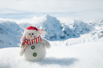 Winter holiday - happy snowman in mountains