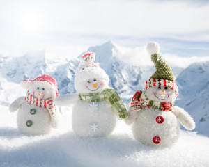 Winter holiday - happy snowman friends in mountains