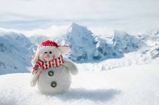 Winter holiday - happy snowman in mountains