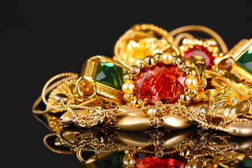Various gold jewellery on black background