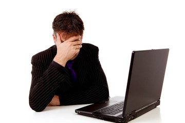 Businessman sitting behind desk is in despair