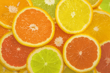 Sliced citrus fruits in different colors, background