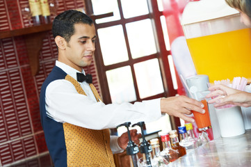 Cheerful arab barman at counter