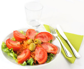 Piatto d'insalata con posate e bicchiere
