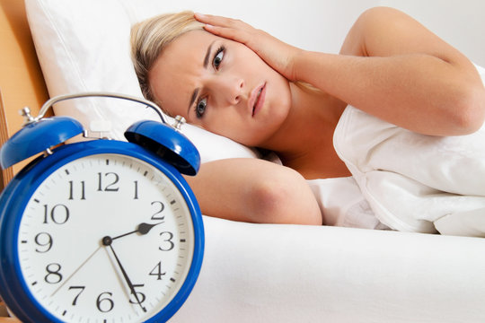 Schlaflos mit Uhr in der Nacht.