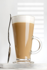 coffee latte with frothy milk in tall glass