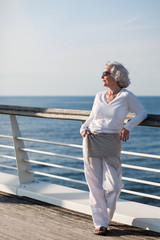 attraktive Seniorin genießt die Kreuzfahrt auf dem Sonnendeck