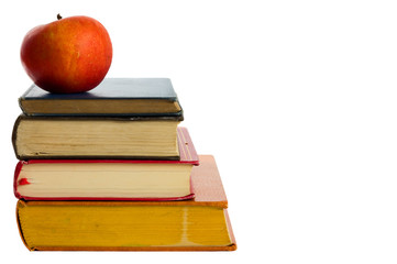 a pile of books and an apple isolated on a white background.