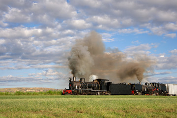 Fototapeta na wymiar Vintage steam locomotive with billowing smoke and steam