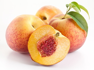 Ripe peach fruit with leaves and slises on white background.