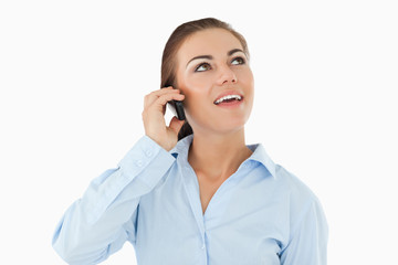 Smiling businesswoman looking upwards while on her phone