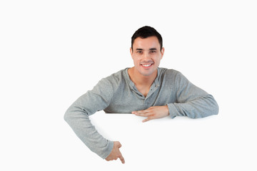 Young male pointing at banner below him