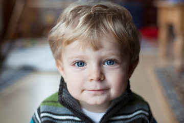 Adorable toddler boy with blue eyes and blond hairs