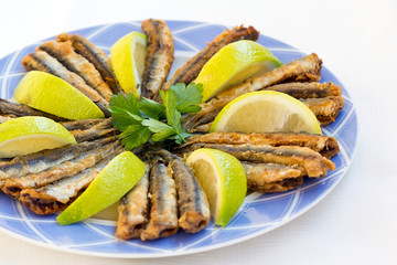 Fried anchovies with slice of lemon and parsley