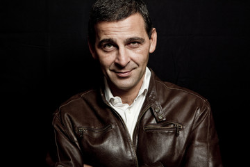 Fototapeta premium portrait of a cool mature man with leather jacket over black bac