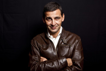 Obraz premium portrait of a cool mature man with leather jacket over black bac