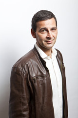 portrait of a cool mature man with leather jacket over white bac