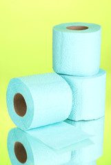 blue rolls of toilet paper on green background