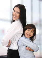 Young mother and son standing , back to back indoor