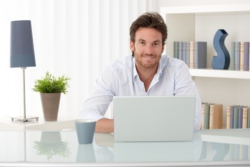Portrait of man at home with computer
