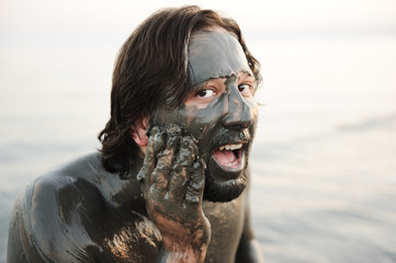 Man in a bathing of natural mineral mud from the dead sea