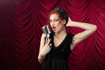 beautiful redhead woman singing into vintage microphone