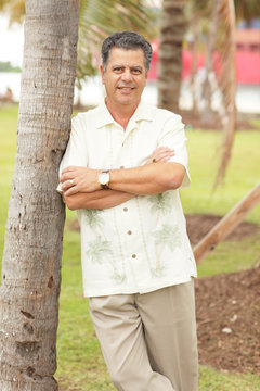 Man leaning on a palm tree