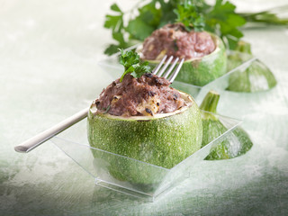 stuffed zucchinis on glass over green backgrond