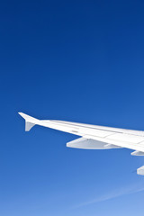 wing of aircraft in clear blue sky - travel concept