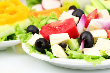 Tasty greek salad on plate isolated on white