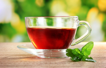 nice cup of tea and mint on green background