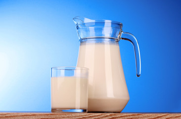 Pitcher and Glass with milk on blue background