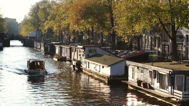 Boat passing in front of houseboats in Amsterdam