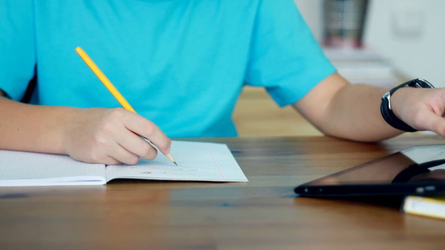 Boy hands doing homework using tablet computer