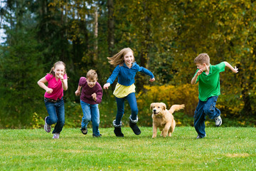 Obraz premium Group of kids racing a dog