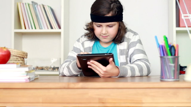 Young teenager with tablet computer by the desk, steadicam shot